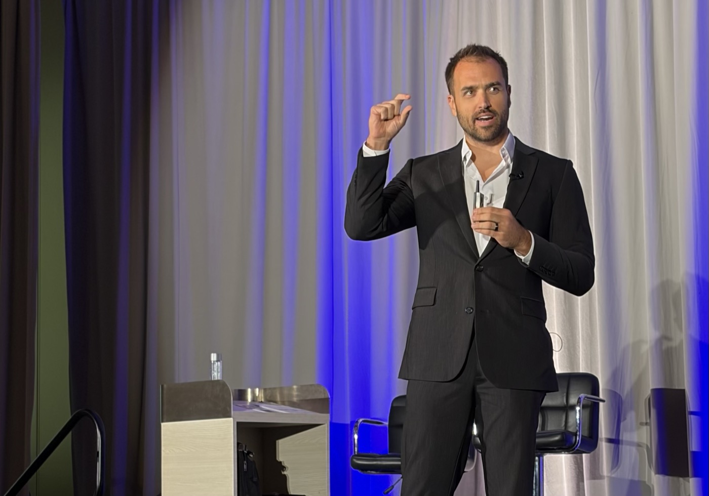 Nick Fischer presenting on stage at a chiropractic event
